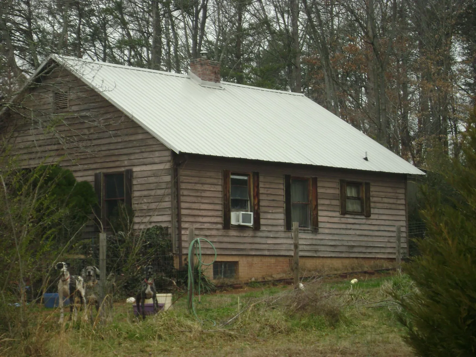 White metal roof on an old wood sided farmhouse, from a Metal Roof Installation job in Topeka